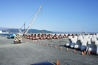 地盤沈下した防波堤の復旧作業